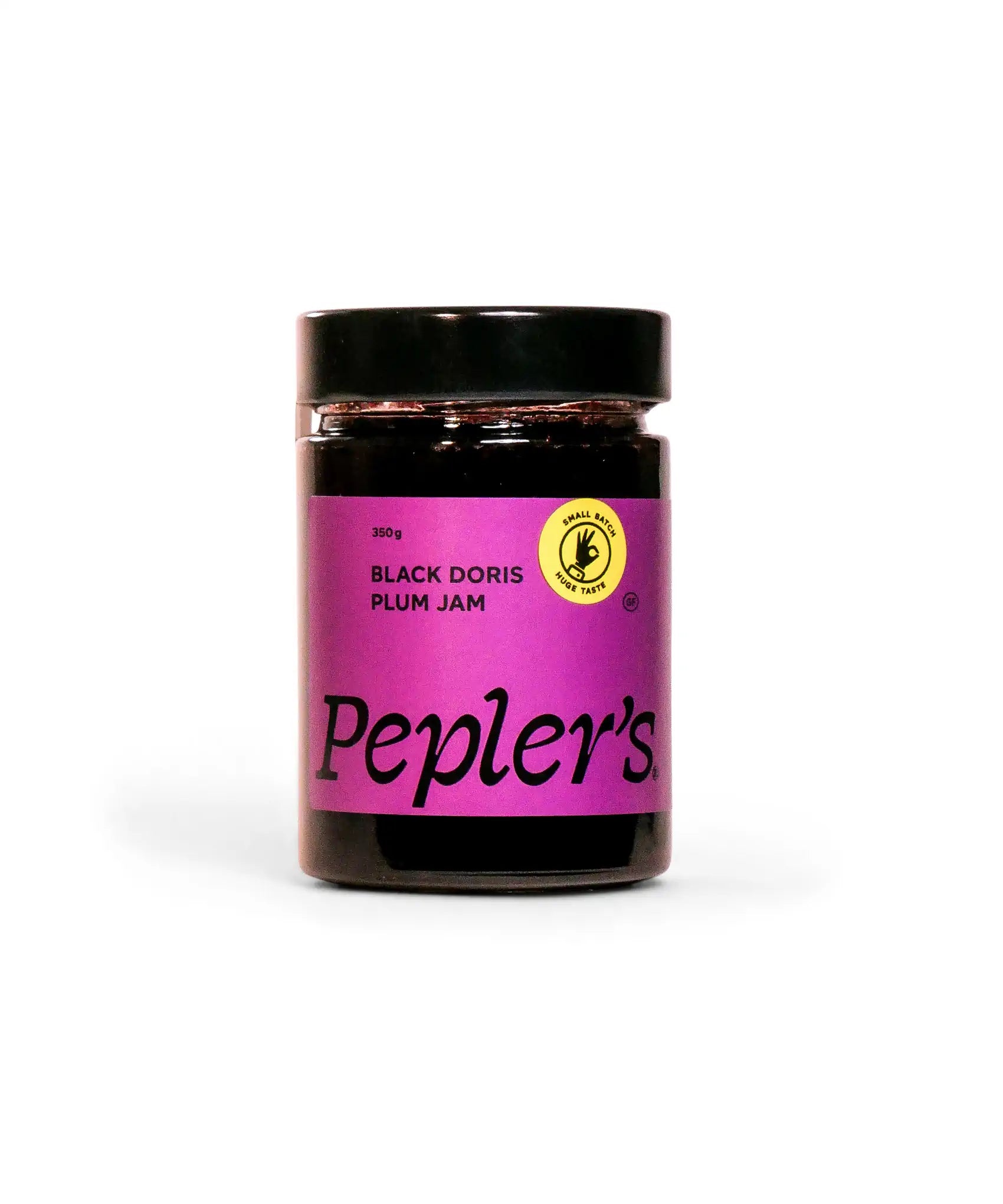 A jar of Pepler's Black Doris Plum Jam, featuring a vibrant purple label with the brand name "Pepler's" prominently displayed. The jar holds 350 grams of jam and includes a yellow circular emblem indicating it's handmade, with text highlighting “small batch, huge taste.” The jar has a black lid, and the jam is thick and dark in appearance. The background is a plain white, emphasising the product.