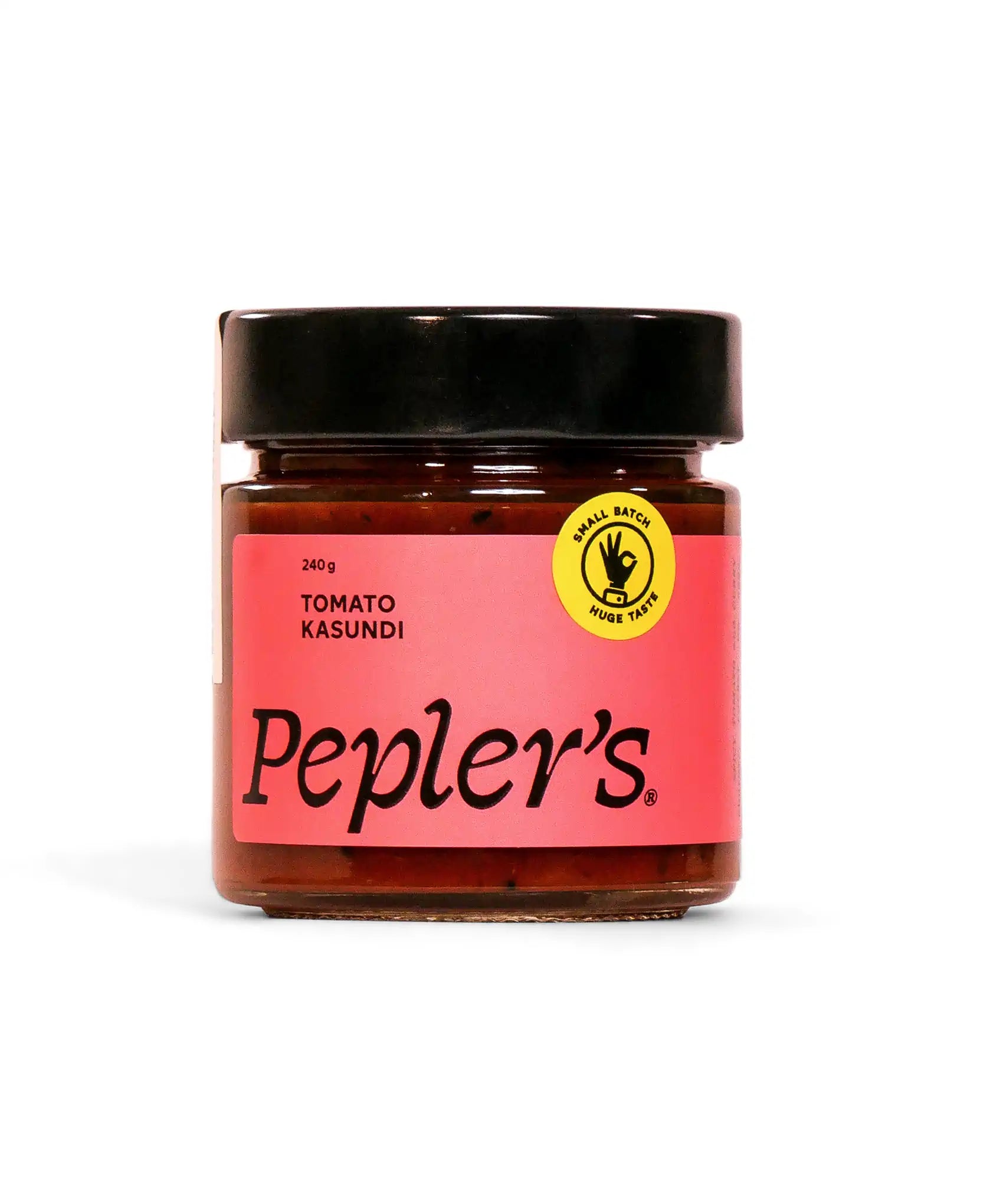 A glass jar of Pepler's Tomato Kasundi, featuring a red label with black text. The jar holds 240 grams of the condiment and is topped with a black lid. A yellow circular sticker on the label highlights "Small Batch Huge Taste," emphasising the artisanal nature of the product. The background is plain white, allowing the jar's vibrant colours to stand out.